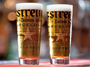 2 kozarca točenega piva Estrella v promocijskih kozarcih na barovskem pultu